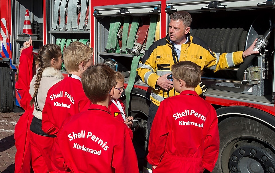 Kinderen luisteren naar uitleg brandweerman